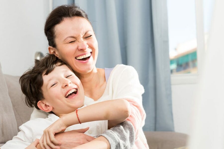 single mother with her son on the sofa laughing