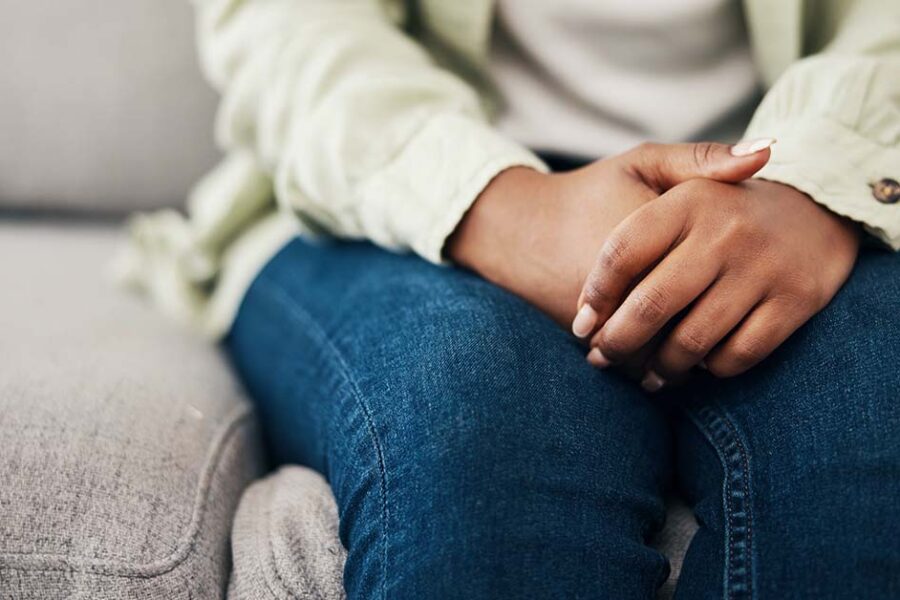 anxious hands are folded over a person's lap